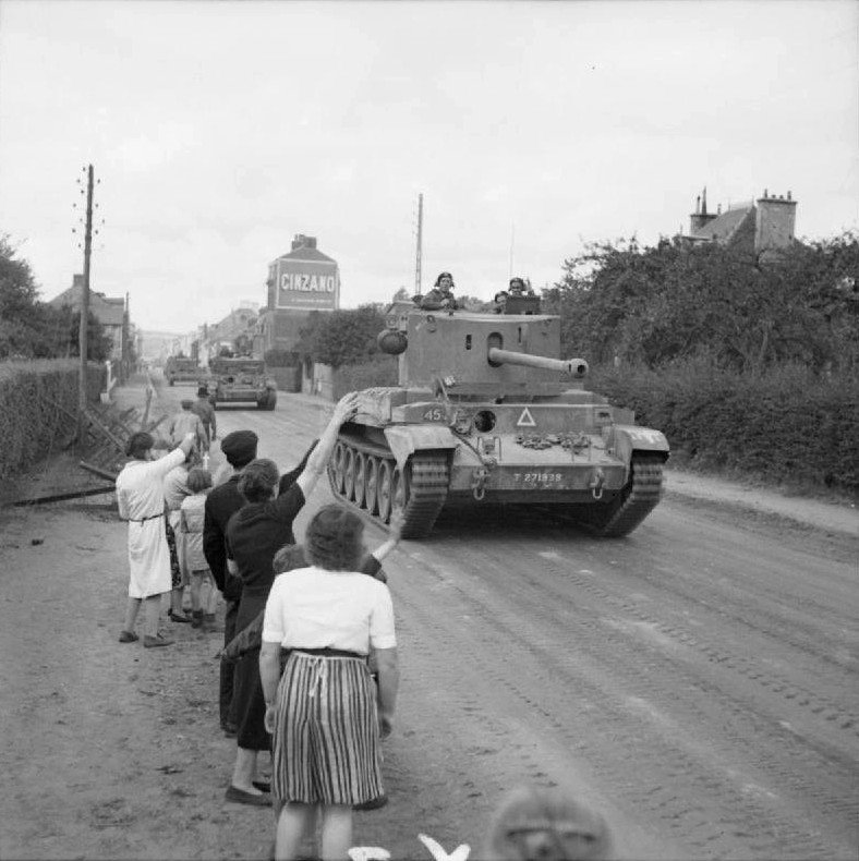 A30 Challenger foreground with Cromwell tanks in background, 2nd Northamptonshire Yeomanry, 11th Armoured Division, passing through Flers, France, 17 August 1944. visually Shows showing Challenger-Cromwell mixed-unit context.