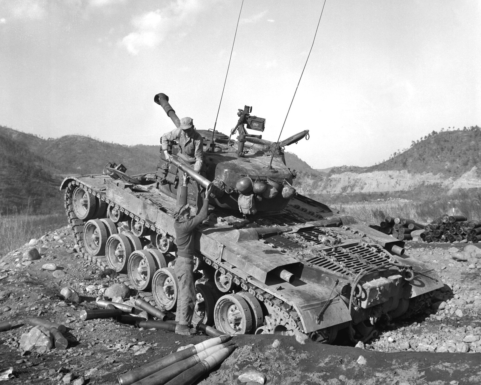 Marine tankmen load ammunition for another firing mission against enemy positions somewhere in Korea, 1950-1953. exact date and location are not specified in the source caption.